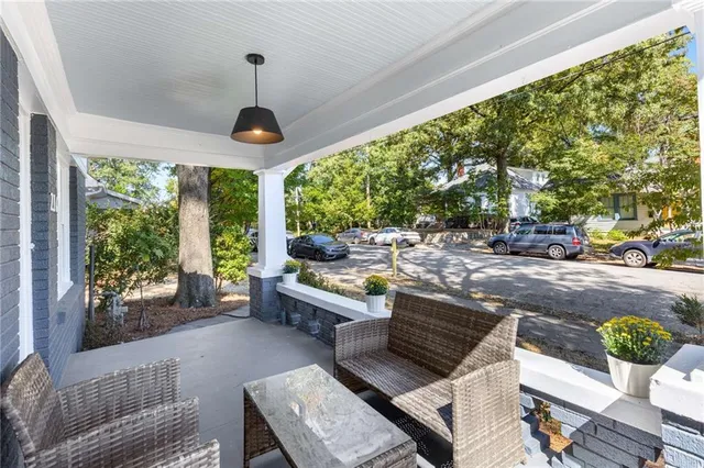 a living room with patio furniture and a floor to ceiling window