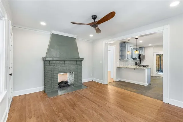 a view of empty room with kitchen and fireplace