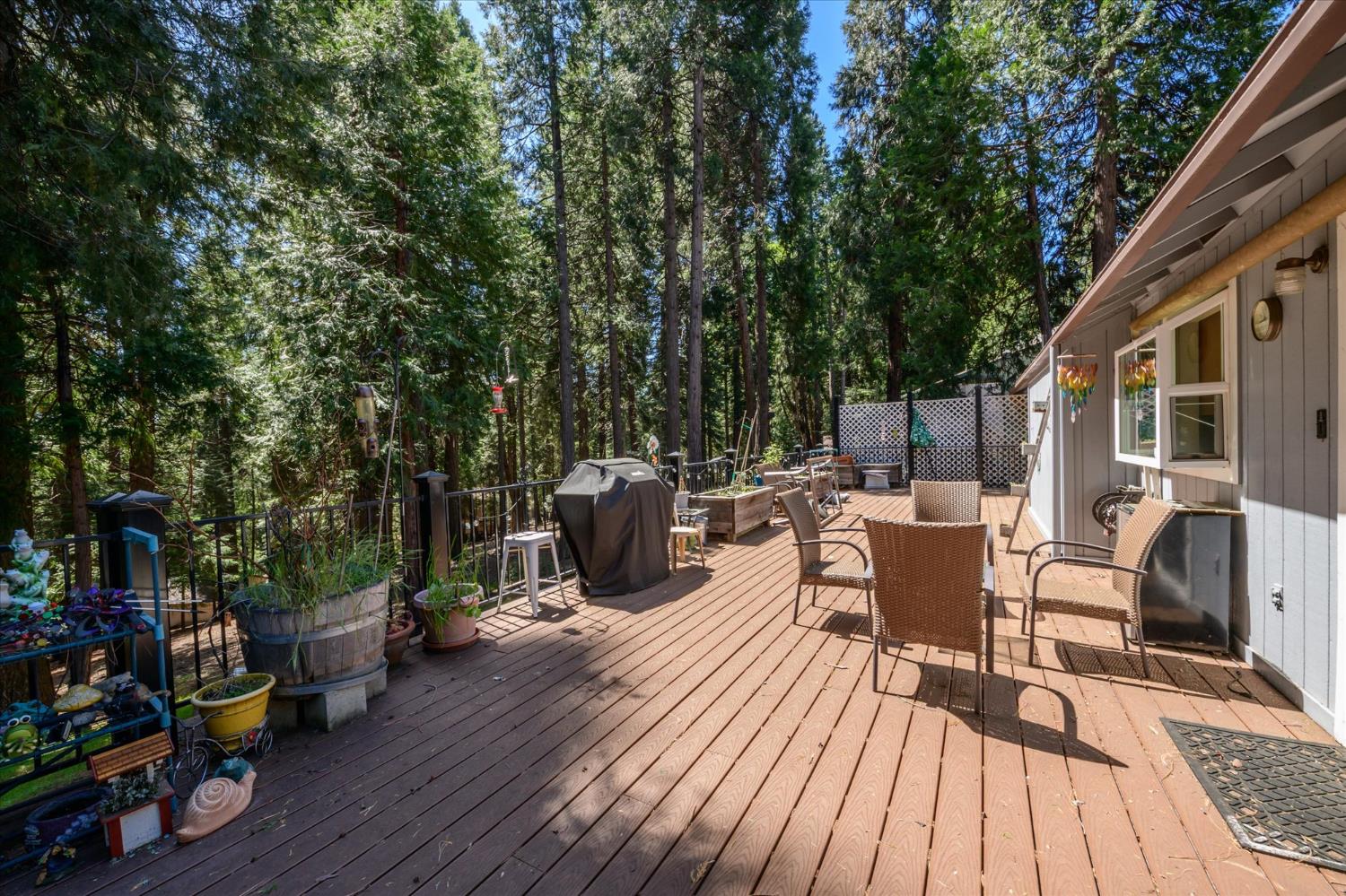 6480 Granite Trail Pollock Pines, CA 95726 - Photo 19 of 23 a view of a patio with table and chairs and potted plants with wooden floor and fence