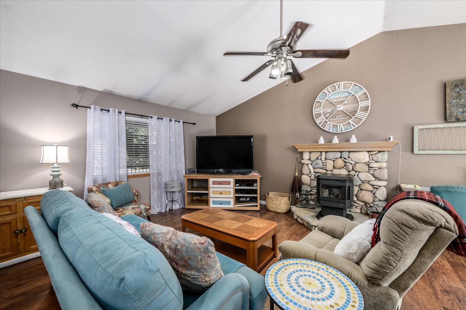 6480 Granite Trail Pollock Pines, CA 95726 - Photo 6 of 23 a living room with furniture a flat screen tv and a fireplace
