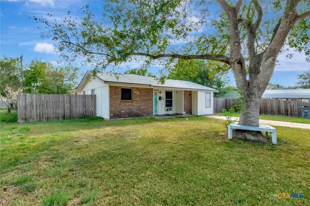 a view of a house with a yard and sitting area