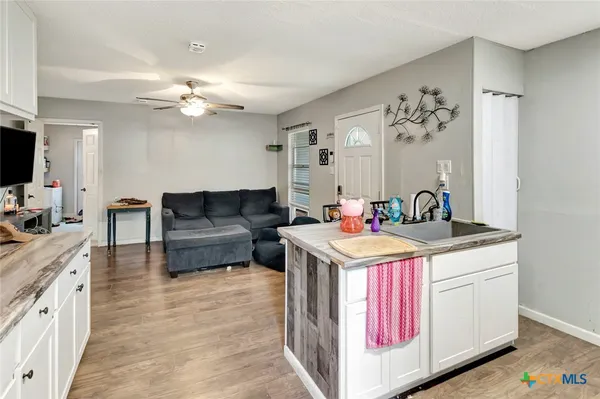 a living room with kitchen island granite countertop furniture and a kitchen view