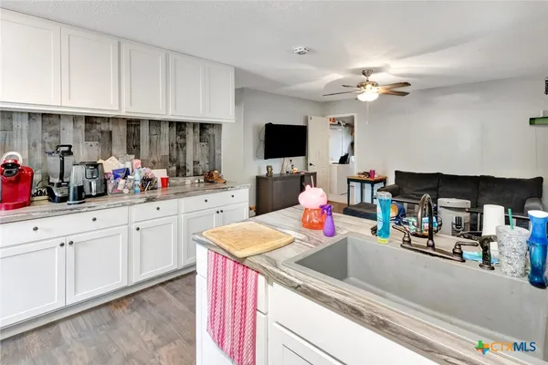 a kitchen filled with stainless steel appliances white cabinets and a sink