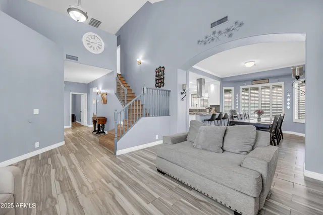 a living room with furniture a flat screen tv and a large window