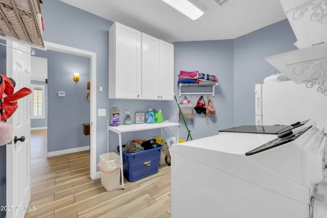 a bedroom with a bed potted plant on the dresser and a chandelier