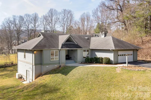 a front view of a house with a yard covered in snow
