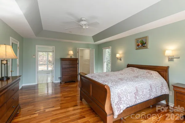 a spacious bedroom with a bed and wooden floor