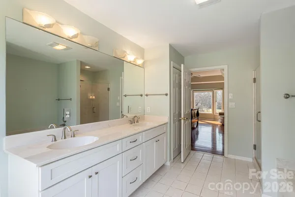 a bathroom with a sink a toilet a mirror and shower
