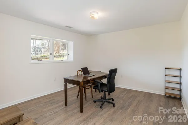 a view of a workspace with furniture and a window