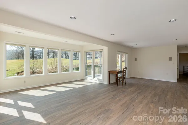 a view of empty room with wooden floor and furniture
