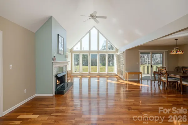 a view of an empty room with furniture a fireplace and wooden floor