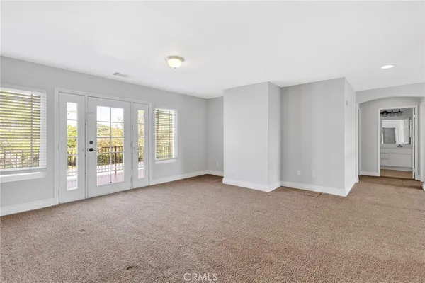 a view of an empty room with closet and a window