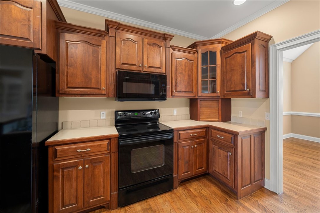 128 Cayman Way Anderson, SC 29621 - Photo 13 of 48 This functional kitchen features rich wood cabinetry and essential appliances.
