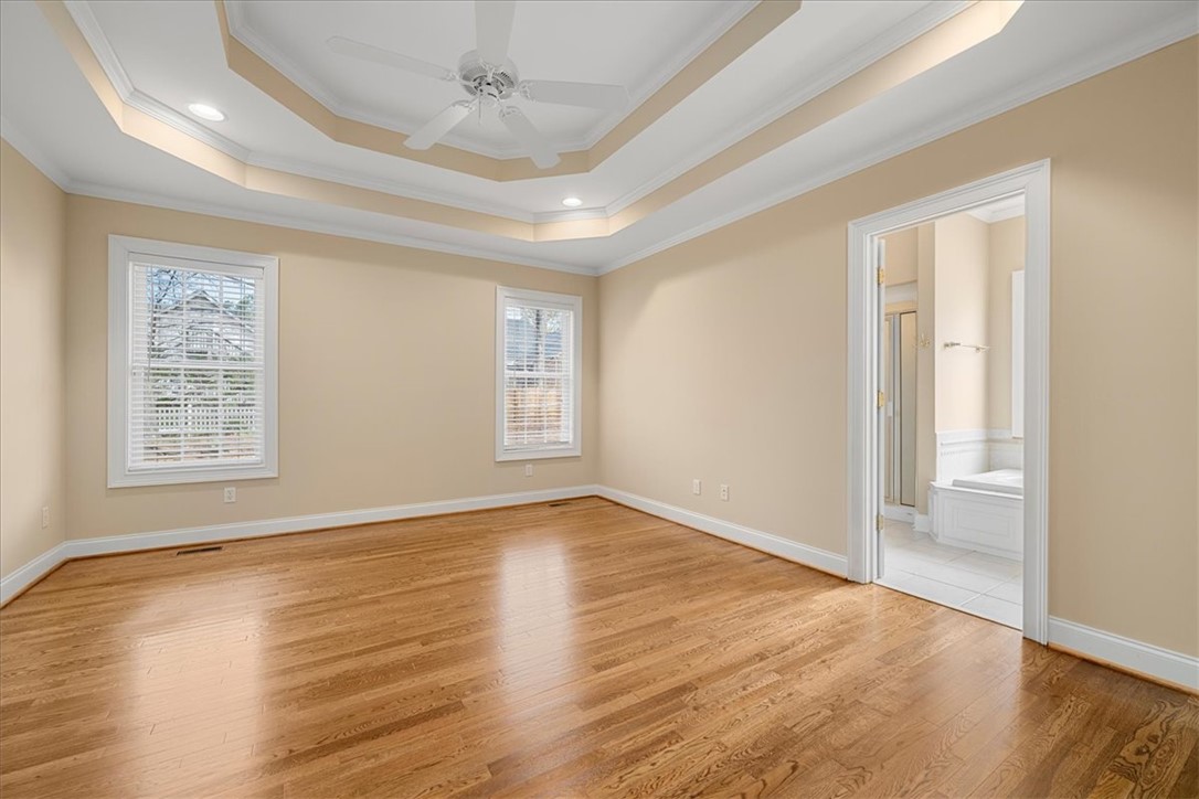 128 Cayman Way Anderson, SC 29621 - Photo 19 of 48 Bright and airy, this bedroom features rich hardwood flooring and elegant tray ceilings.