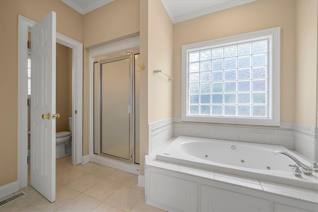 128 Cayman Way Anderson, SC 29621 - Photo 23 of 48 Relax in this tranquil bathroom featuring a soaking tub and elegant tile flooring.