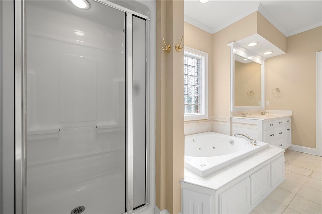 128 Cayman Way Anderson, SC 29621 - Photo 24 of 48 This serene bathroom offers a spacious walk-in shower and a luxurious soaking tub for ultimate relaxation.