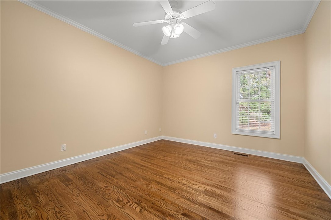 128 Cayman Way Anderson, SC 29621 - Photo 29 of 48 This spacious bedroom offers ample natural light and beautiful hardwood flooring.