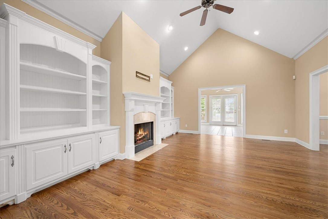 128 Cayman Way Anderson, SC 29621 - Photo 5 of 48 This airy living space features a cozy fireplace and expansive hardwood floors, perfect for relaxation.