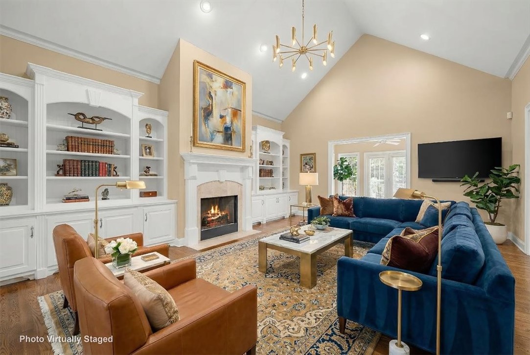 128 Cayman Way Anderson, SC 29621 - Photo 6 of 48 This bright living area features built-in shelving, a fireplace, and soaring vaulted ceilings. Virtually furnished