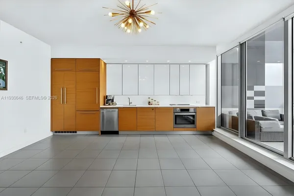 a large white kitchen with a sink and cabinets