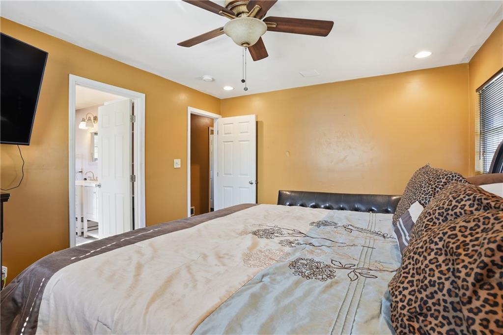 8926 Ashton Road Jonesboro, GA 30238 - Photo 15 of 32 a bedroom with a bed and a chandelier