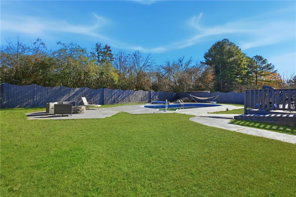8926 Ashton Road Jonesboro, GA 30238 - Photo 24 of 32 a swimming pool with outdoor seating and yard