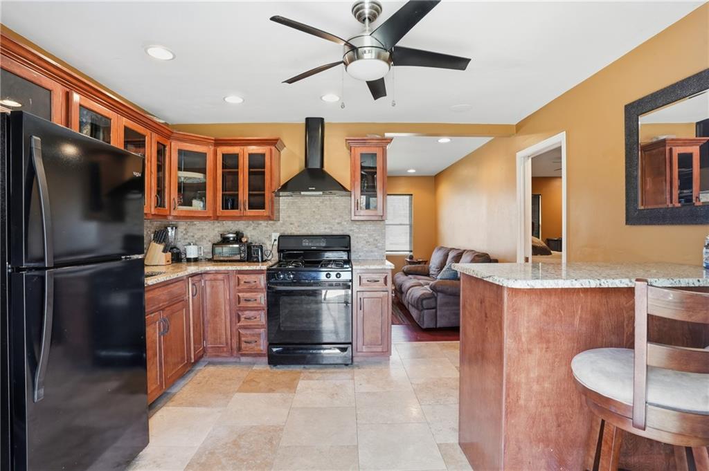 8926 Ashton Road Jonesboro, GA 30238 - Photo 5 of 32 a kitchen with refrigerator a sink and chairs