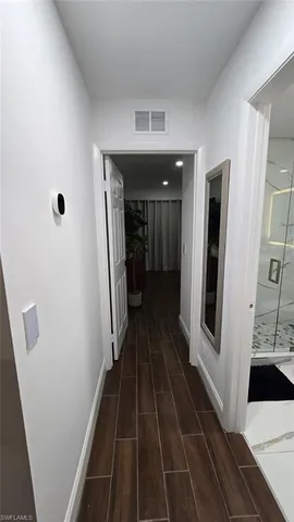 a bedroom with a bed and a table with wooden floor