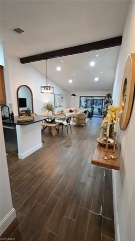 a living room with furniture a table and kitchen view