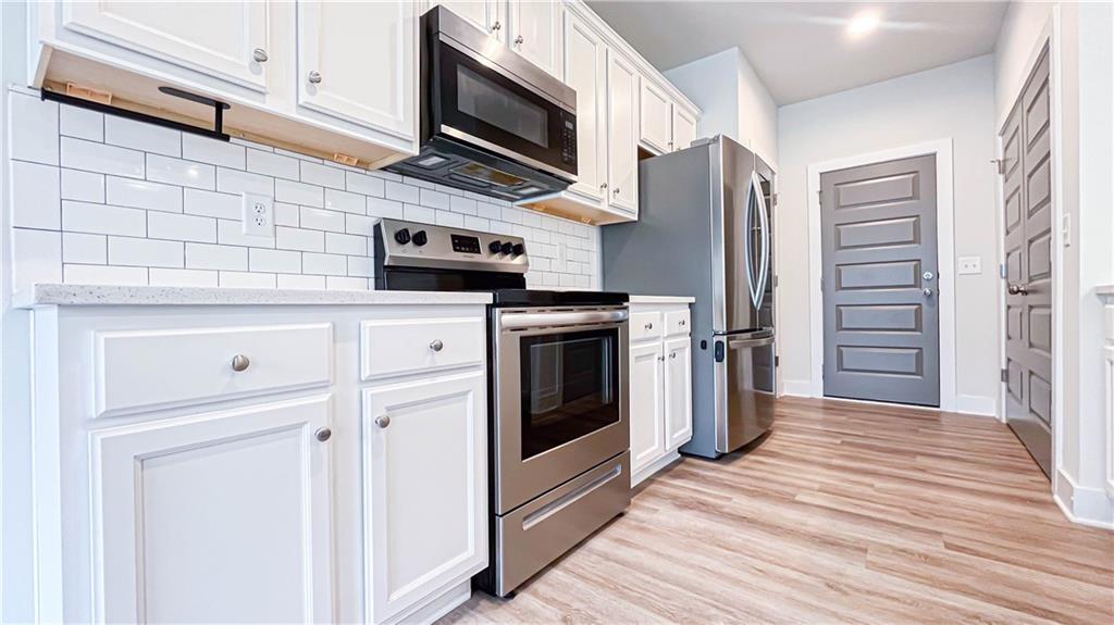 740 Eudora Welty Way Athens, GA 30607 - Photo 14 of 57 a kitchen with stainless steel appliances white cabinets a stove top oven