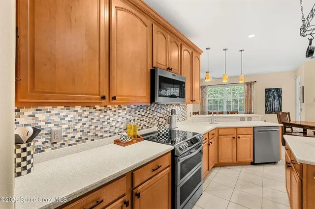 a living room with stainless steel appliances kitchen island granite countertop furniture and a fireplace