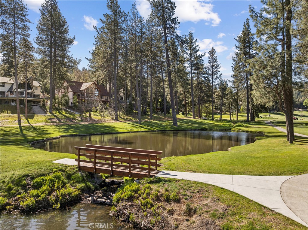 524 Golf Course Road Lake Arrowhead, CA 92352 - Photo 2 of 71 a view of a lake with a bench under a large tree