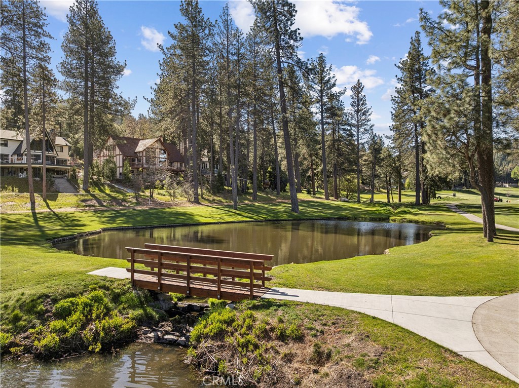 524 Golf Course Road Lake Arrowhead, CA 92352 - Photo 56 of 71 a view of a lake with a bench under a large tree