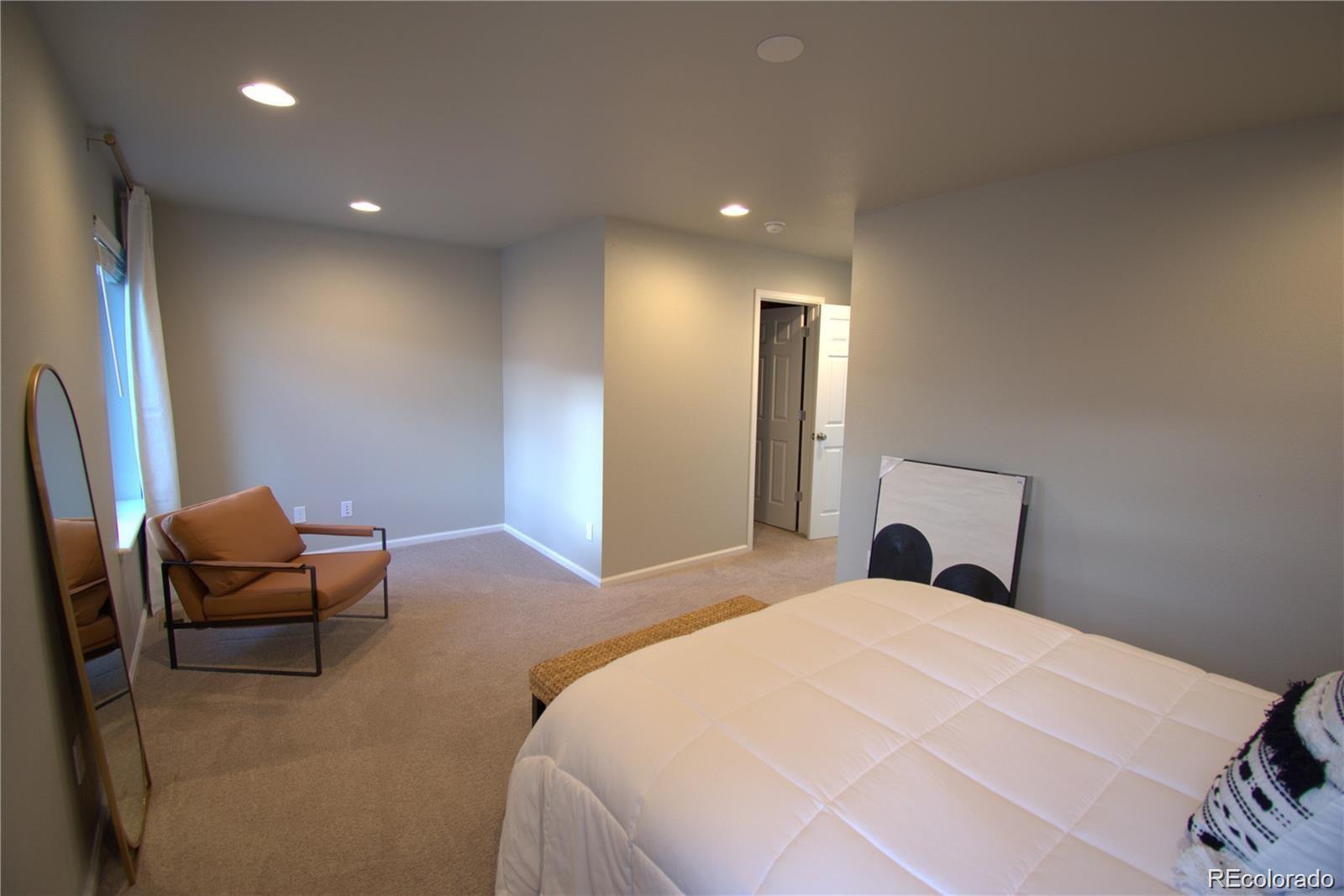 6435 North Dunkirk Street Denver, CO 80249 - Photo 12 of 12 a bedroom with a bed and a chair