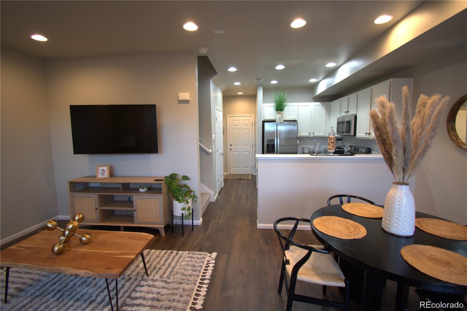 6435 North Dunkirk Street Denver, CO 80249 - Photo 3 of 12 a living room with furniture and a flat screen tv