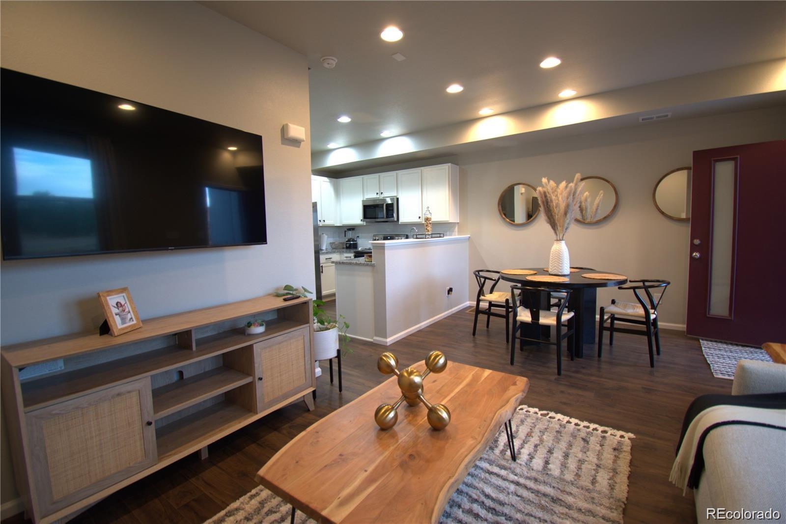 6435 North Dunkirk Street Denver, CO 80249 - Photo 4 of 12 a living room with furniture and a flat screen tv