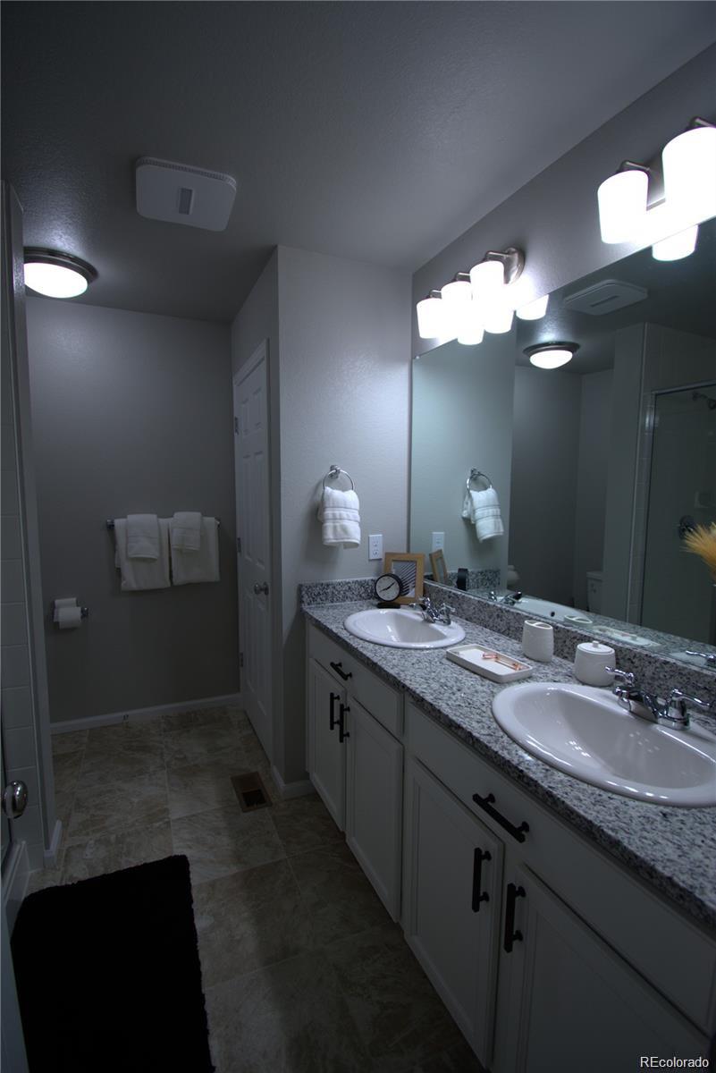 6435 North Dunkirk Street Denver, CO 80249 - Photo 10 of 12 a bathroom with a sink and a mirror
