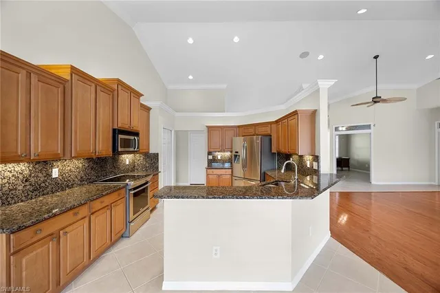 a kitchen with stainless steel appliances granite countertop sink refrigerator and microwave