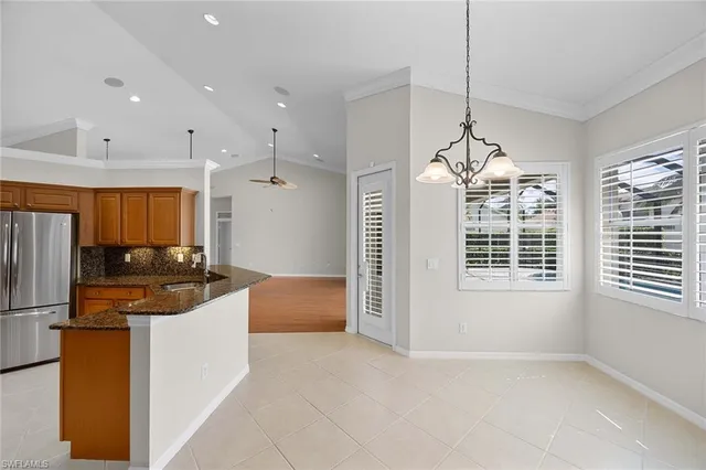 a kitchen with stainless steel appliances kitchen island granite countertop a refrigerator and a stove top oven