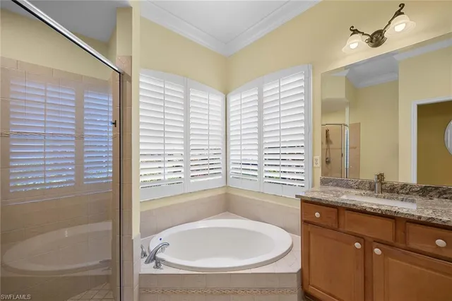 a bathroom with a granite countertop sink and a bathtub