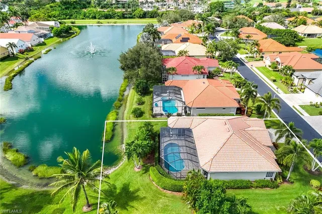 an aerial view of a house with a yard and lake view