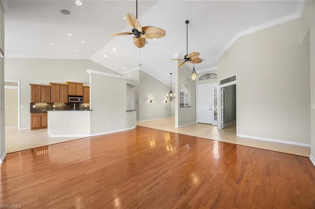 a view of a kitchen with a refrigerator wooden floor and a ceiling fan