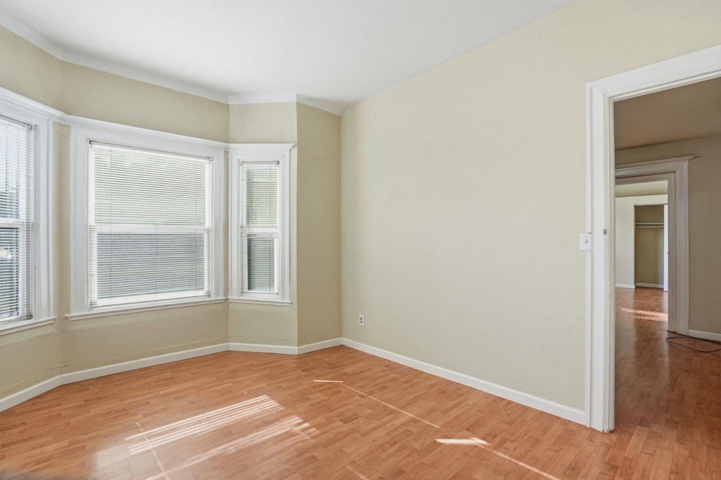 603 Madison Street Oakland, CA 94607 - Photo 25 of 43 a view of an empty room with wooden floor and a window