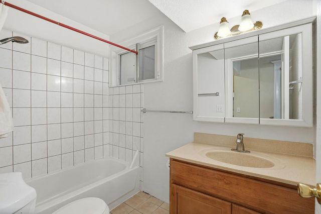 a bathroom with a toilet a sink a mirror and shower