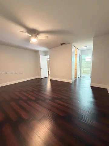 a view of an empty room with wooden floor