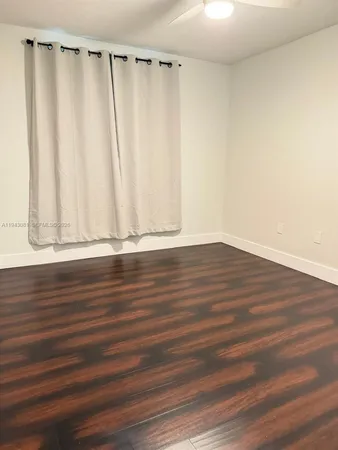 a view of a room with wooden floor and curtain