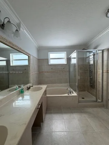 a bathroom with a tub sink vanity and mirror