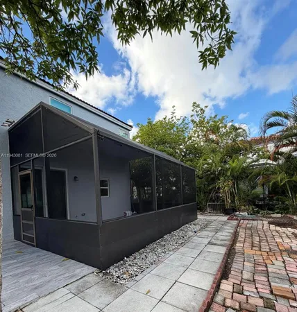 a view of backyard with barbeque grill and wooden fence