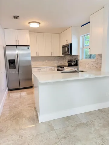 a kitchen with stainless steel appliances a refrigerator sink and microwave