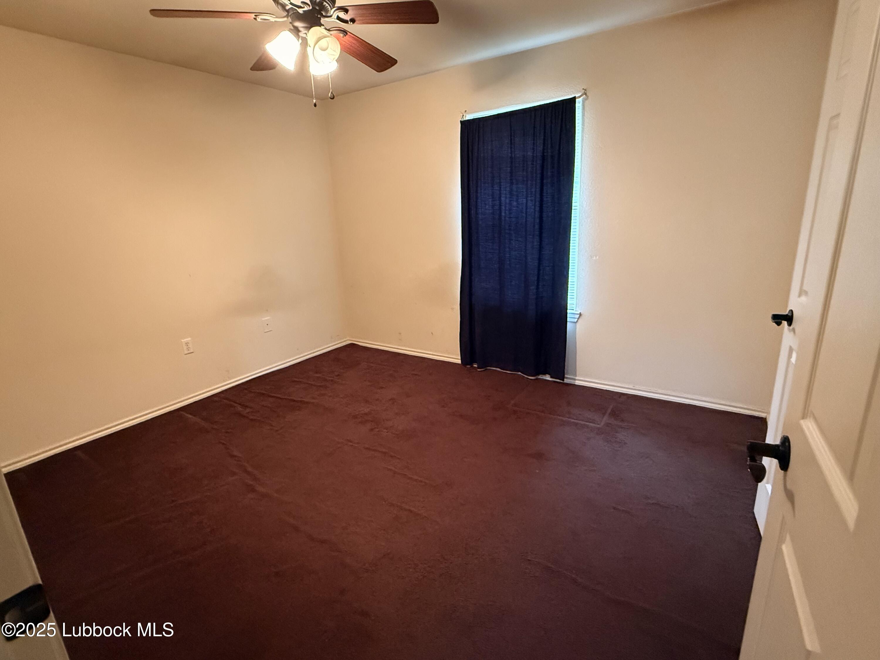 307 East 3rd Street Muleshoe, TX 79347 - Photo 15 of 20 an empty room with a chandelier fan and a window